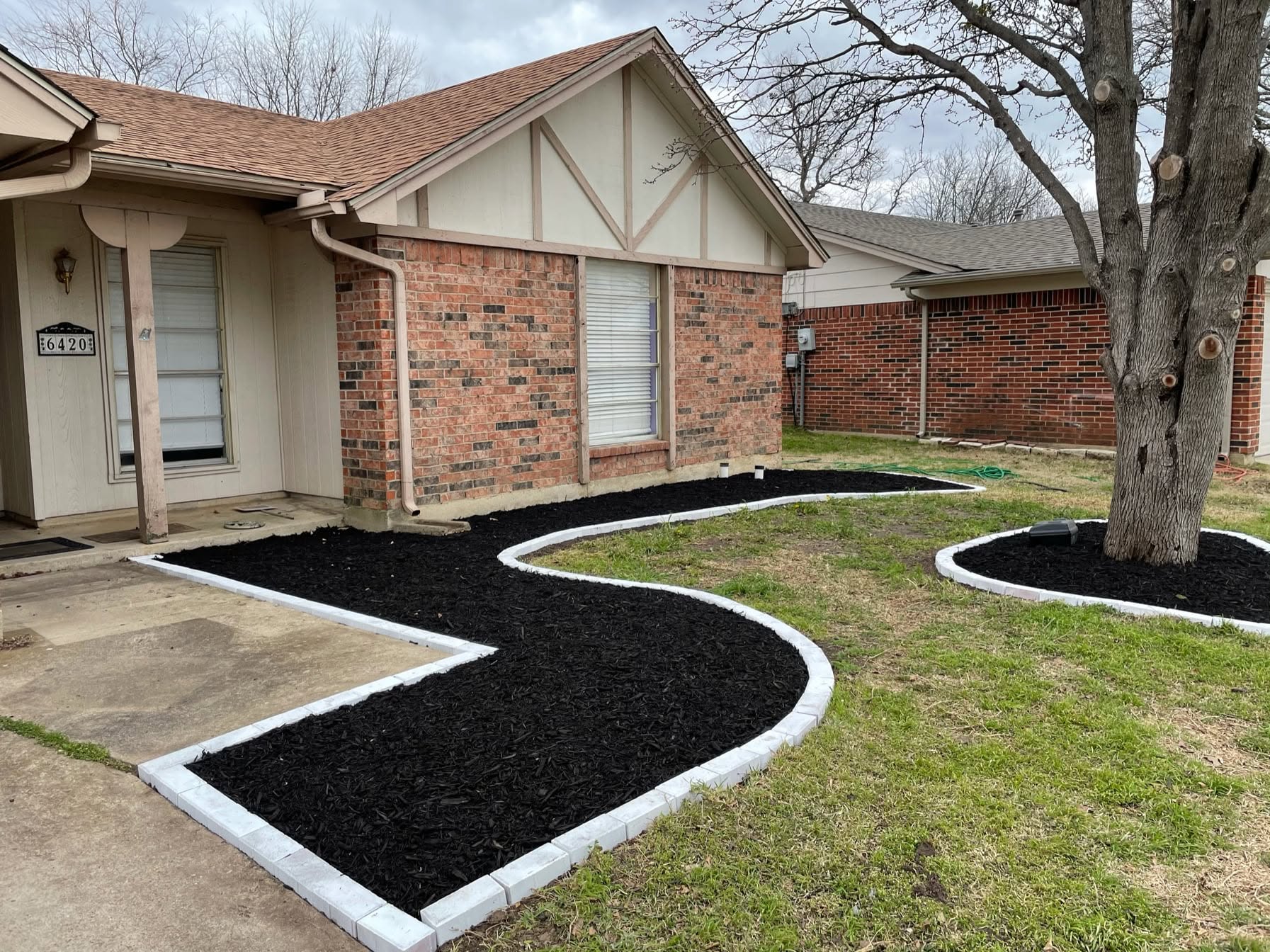 Finished curved front beds filled with fresh black mulch